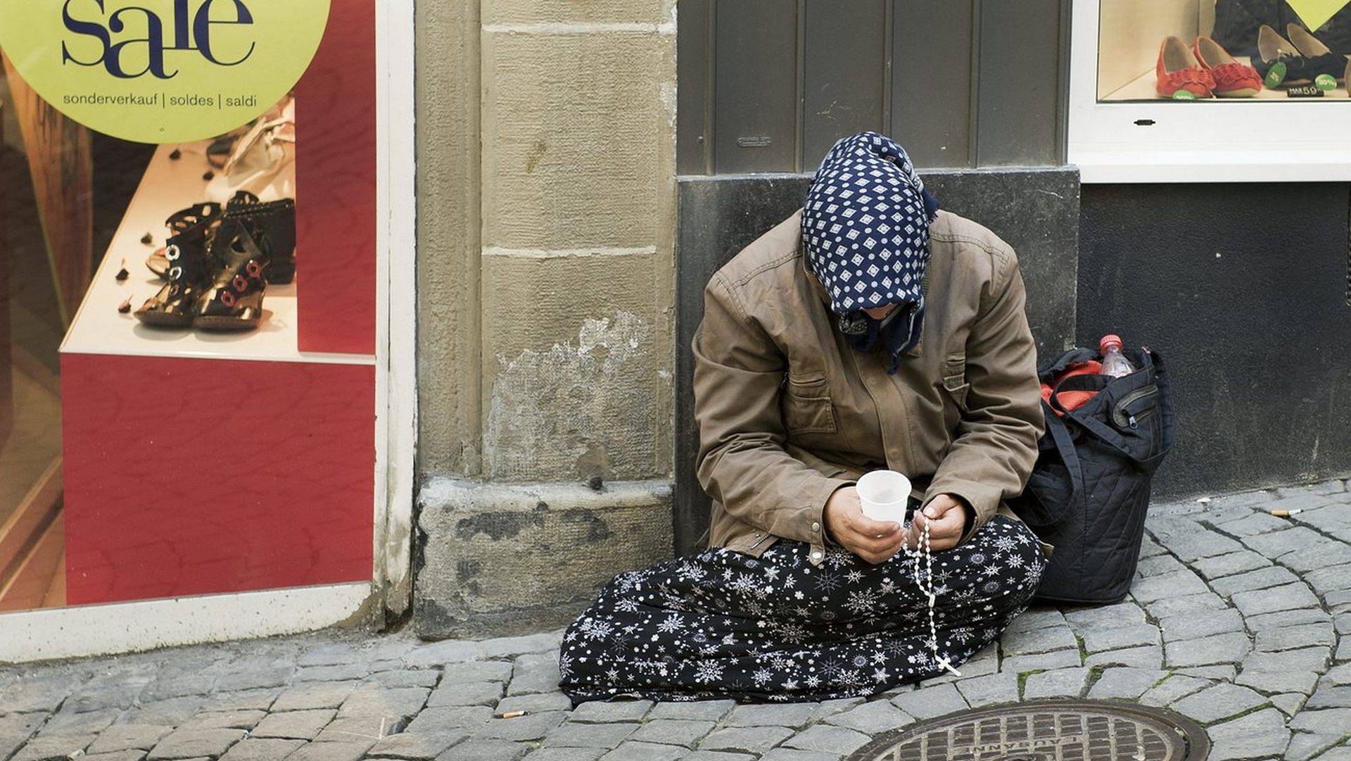 Une mendiante dans une rue de Lausanne (KEYSTONE/Jean-Christophe Bott)