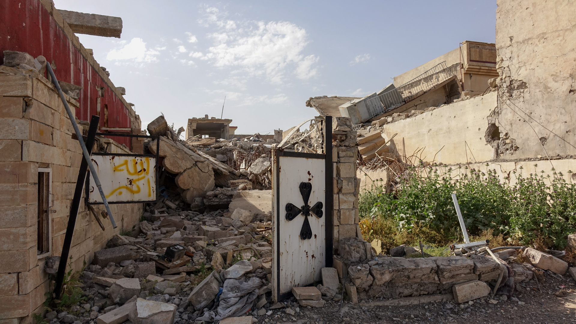 Le village fantôme de Betnaya, dans la plaine de Ninive en Irak. A gauche de la croix chrétienne, le tag en jaune signifie "Allah Akbar" (photo Maurice Page) 
