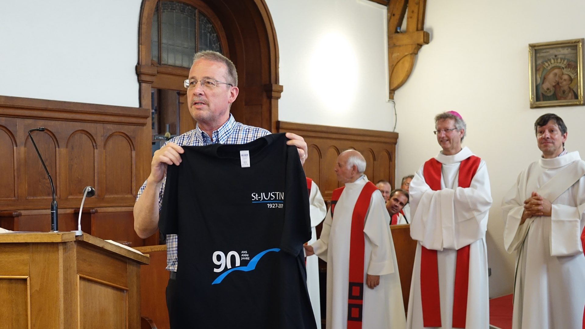 Lorenzo Laini, directeur de la Cité St-Justin de Fribourg, présent le T-shirt du 90e anniversaire de la fondation de l'Oeuvre St-Justin (photo Maurice Page) 
