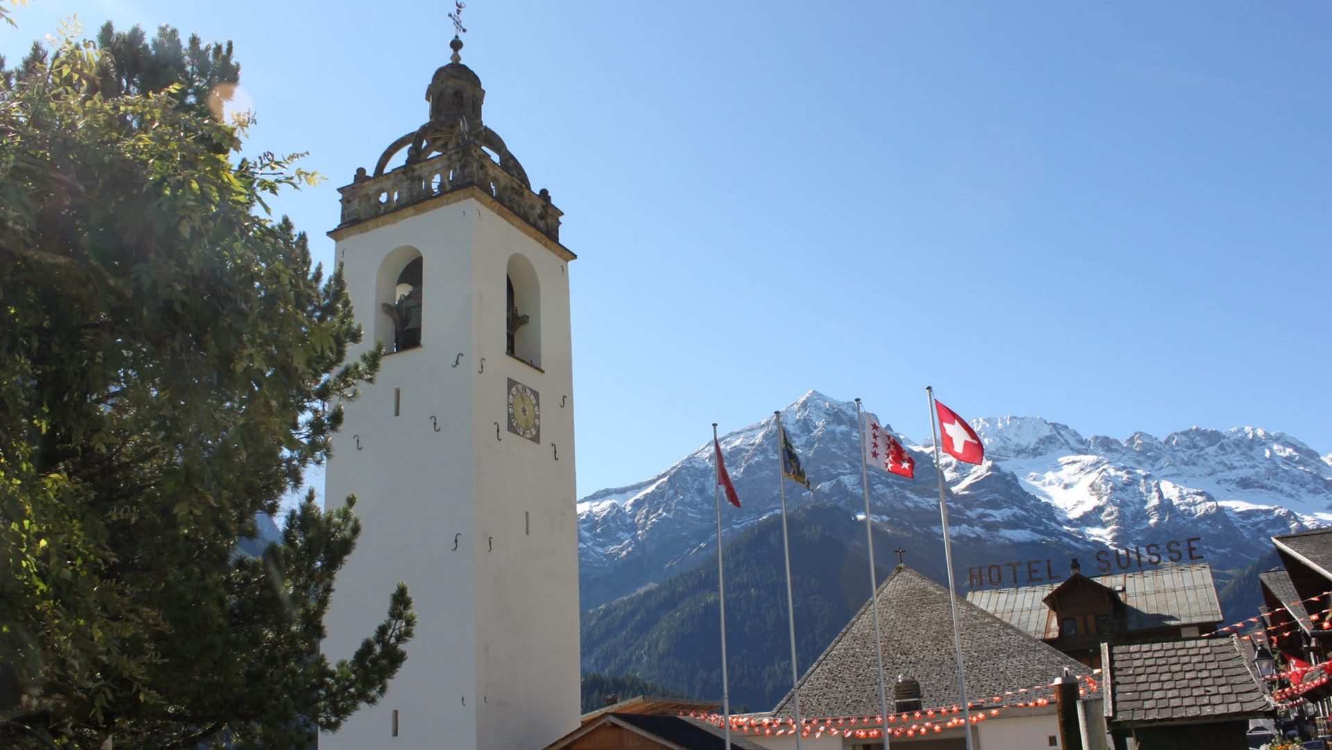 Le clocher baroque de 1725 de l'église de Champéry est surmonté d'une balustrade sur laquelle s’appuient des arcs en pierre entourant la couronne des ducs de Savoie ¦ © Bernard Litzler