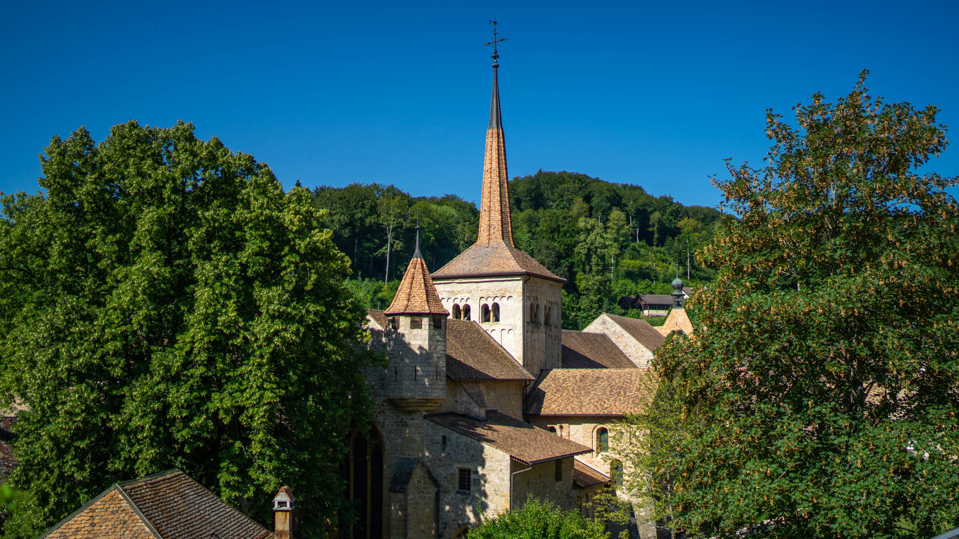 L'abbatiale de Romainmôtier et son écrin de verdure | © Pierre Pistoletti