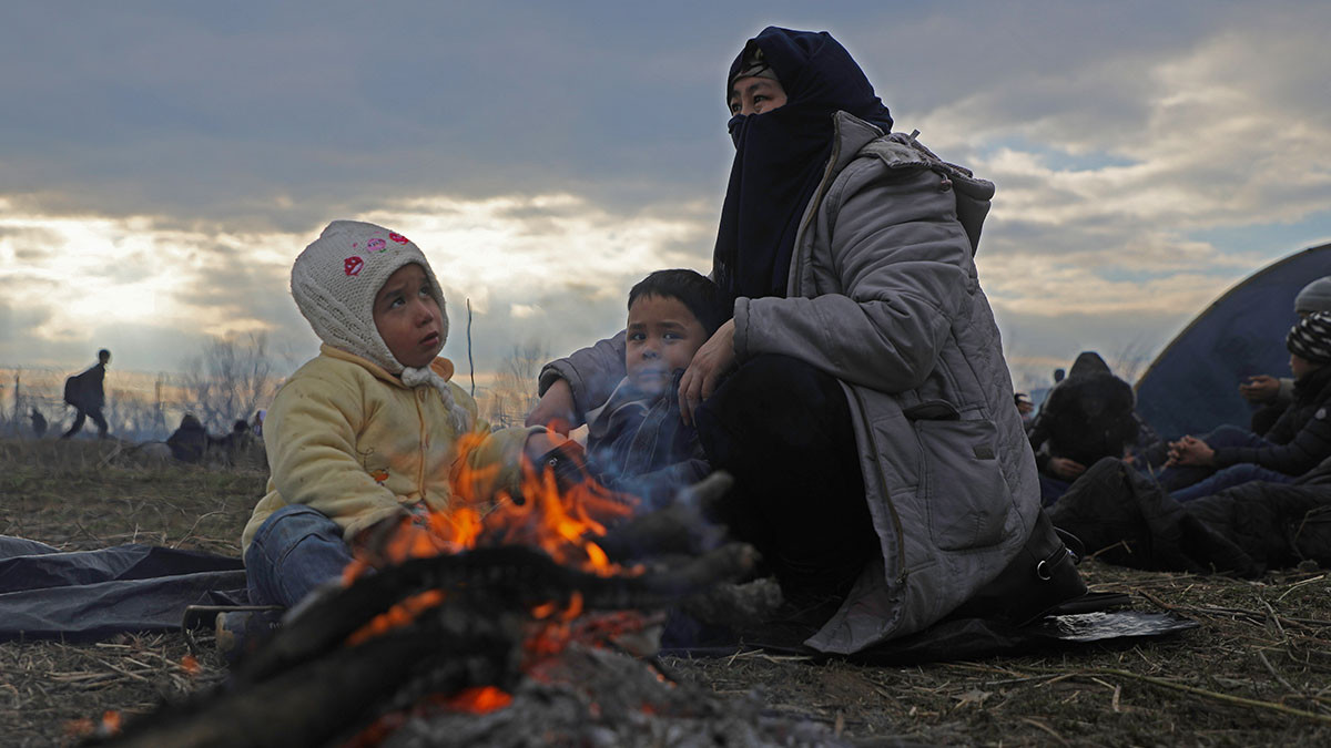 Une famille se réchauffe à Pazarkule, dans le district d'Edirne en Turquie, proche de la frontière grecque (29 février 2020) | © UNICEF/UNI307807/Almohibany