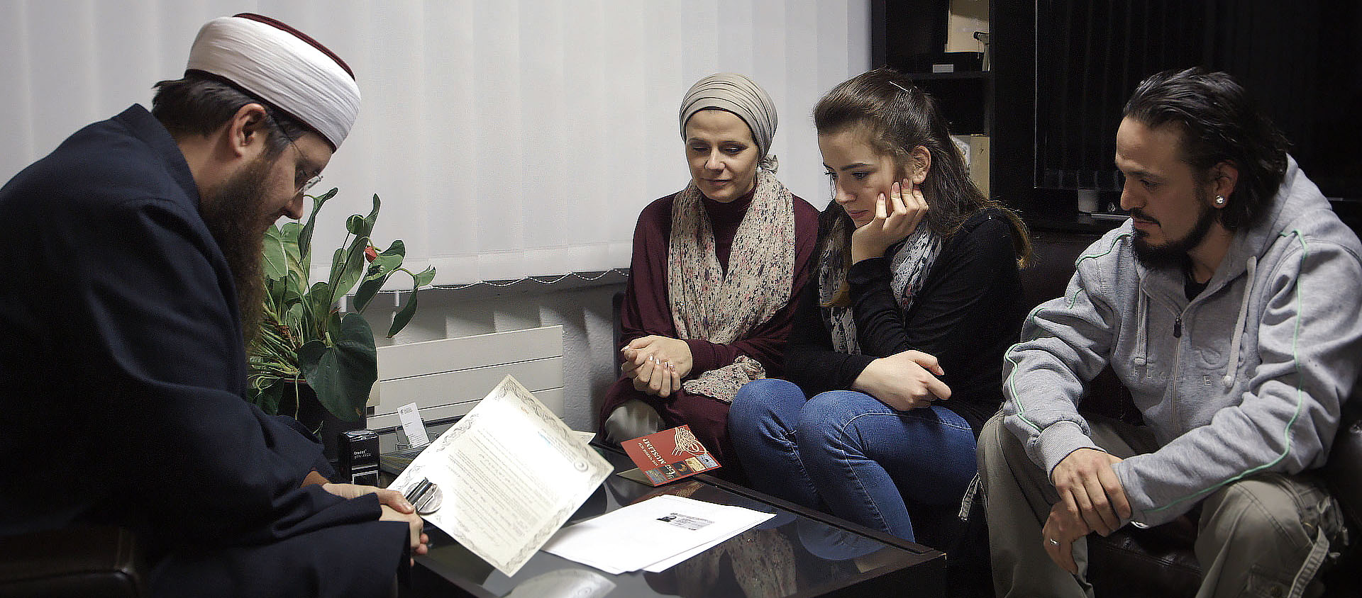 Scène-clé du film, la conversion de Gioia, entourée de sa mère Myriam et de Franco, le mari de celle-ci, chez l'imam Nicolas Blancho, président du Conseil central islamique suisse | © First Hand Films