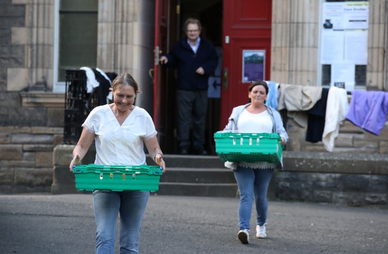 Des bénévoles de l'association Step to Hope transportent des repas dans l'enceinte de l'église de St-Cuthbert, à Edinburgh | © 
Andrew Milligan/PA Wire/PA Images