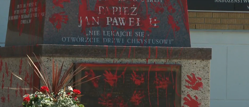 Des marques de mains à la peinture rouge parsèment le socle de la statue de Jean Paul II, à Edmonton (Canada) | capture d'écran Global News