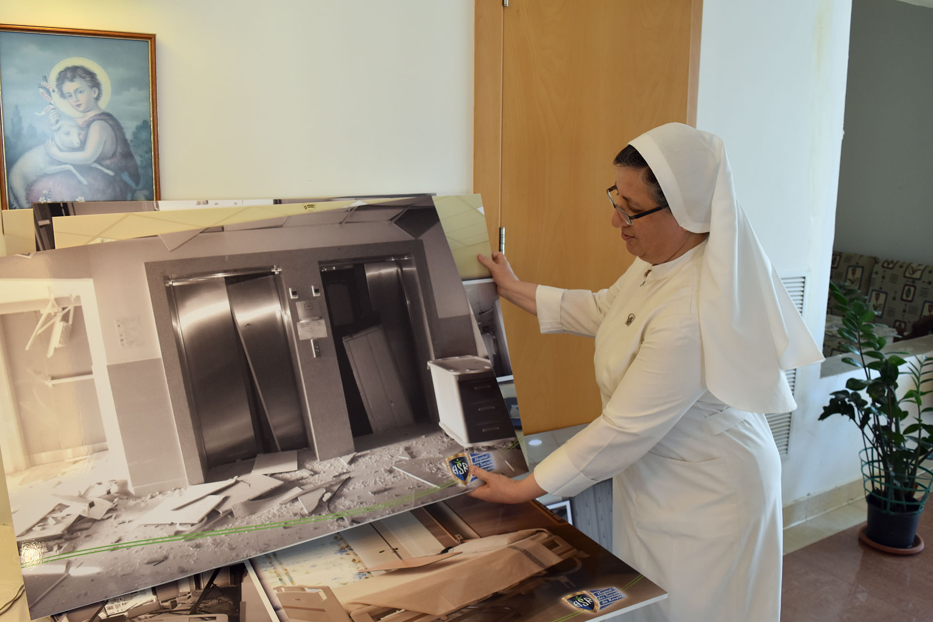 Sœur Marie-Josèphe montre la photo des ascenseurs soufflés par l’explosion du 4 août 2020 | © Bernard Hallet