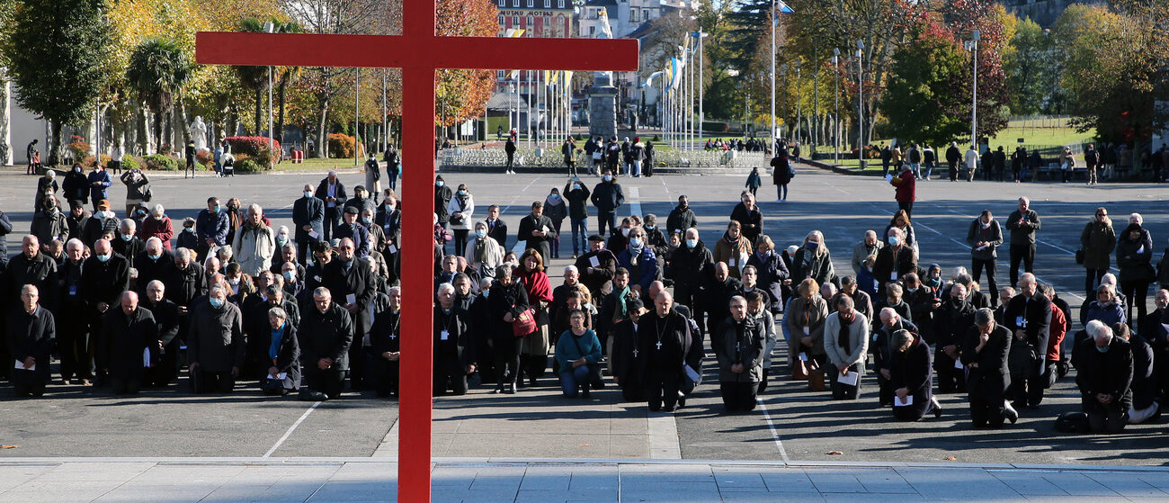 Les évêques se sont agenouillés devant une grande croix rouge dressée au sanctuaire Notre-Dame du Rosaire de Lourdes | © AP Photo/Bob Edme/keystone