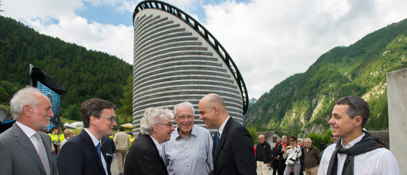 L'architecte Mario Botta salue le conseiller fédéral Alain Berset devant l'église de Mogno (TI) qu'il a réalisée en 1980 | © KEYSTONE/TI-PRESS/Davide Agosta