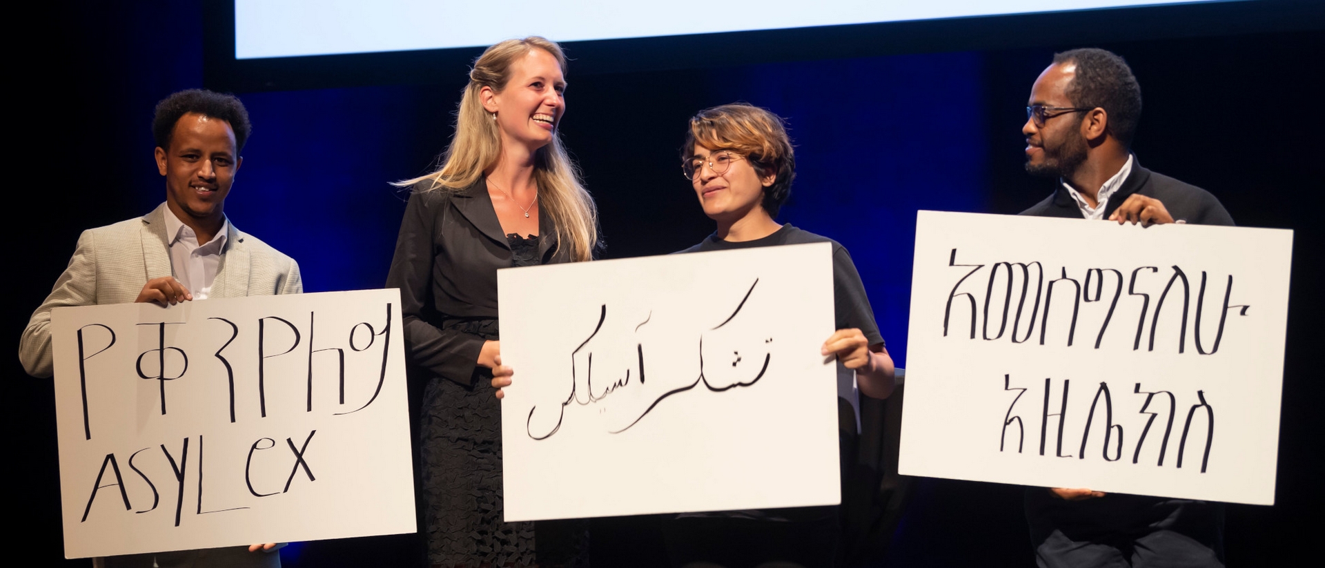 Les clients d'Asylex entourent Lea Hungerbühler pour la remise du Prix Caritas 2022 |  Priska Ketteler Caritas-Suisse