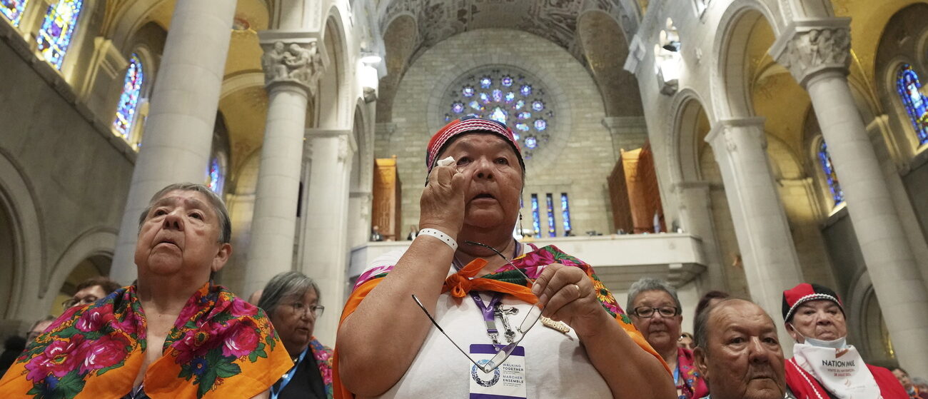 Une femme autochtone essuie une larme lors de la messe du pape François au sanctuaire québécois de Sainte-Anne-de-Beaupré, le 28 juillet 2022 | © Nathan Denette /The Canadian Press via AP/Keystone
