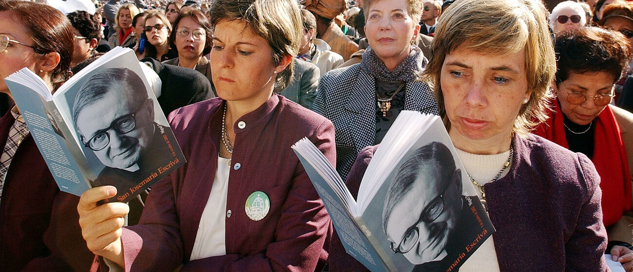 Des pèlerins sur la Place St-Pierre lisent un ouvrage de José Maria Escriva de Balaguer, fondateur de l'Opus Dei | © AP Photo/Gregorio Borgia/Keystone