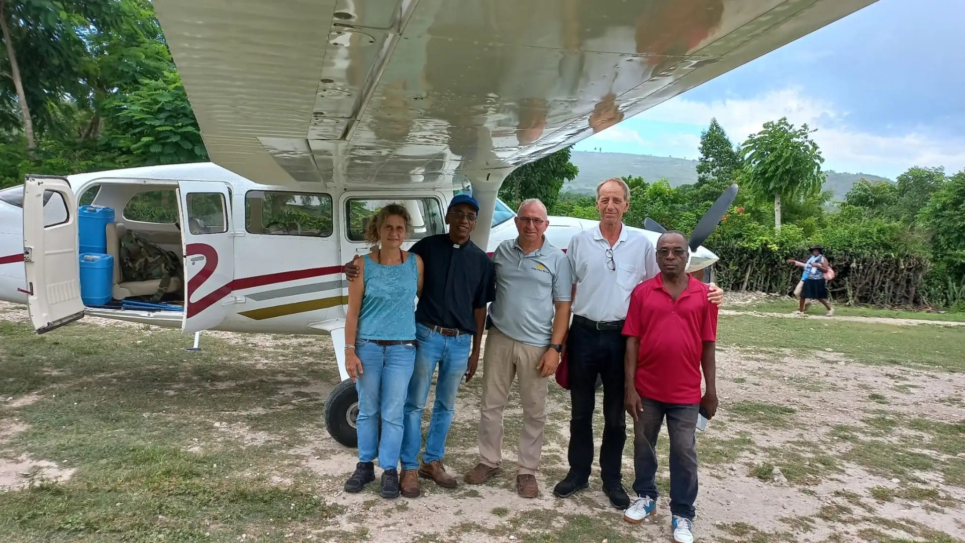 Le couple Agustoni est parti de l'aérodrome de Fond-des-Blancs. A partir de la gauche, Nadia, le Père Yves Voltaire, directeur du Bureau Diocésain d'Éducation, le pilote, Sandro,et le chauffeur     | © CMSI