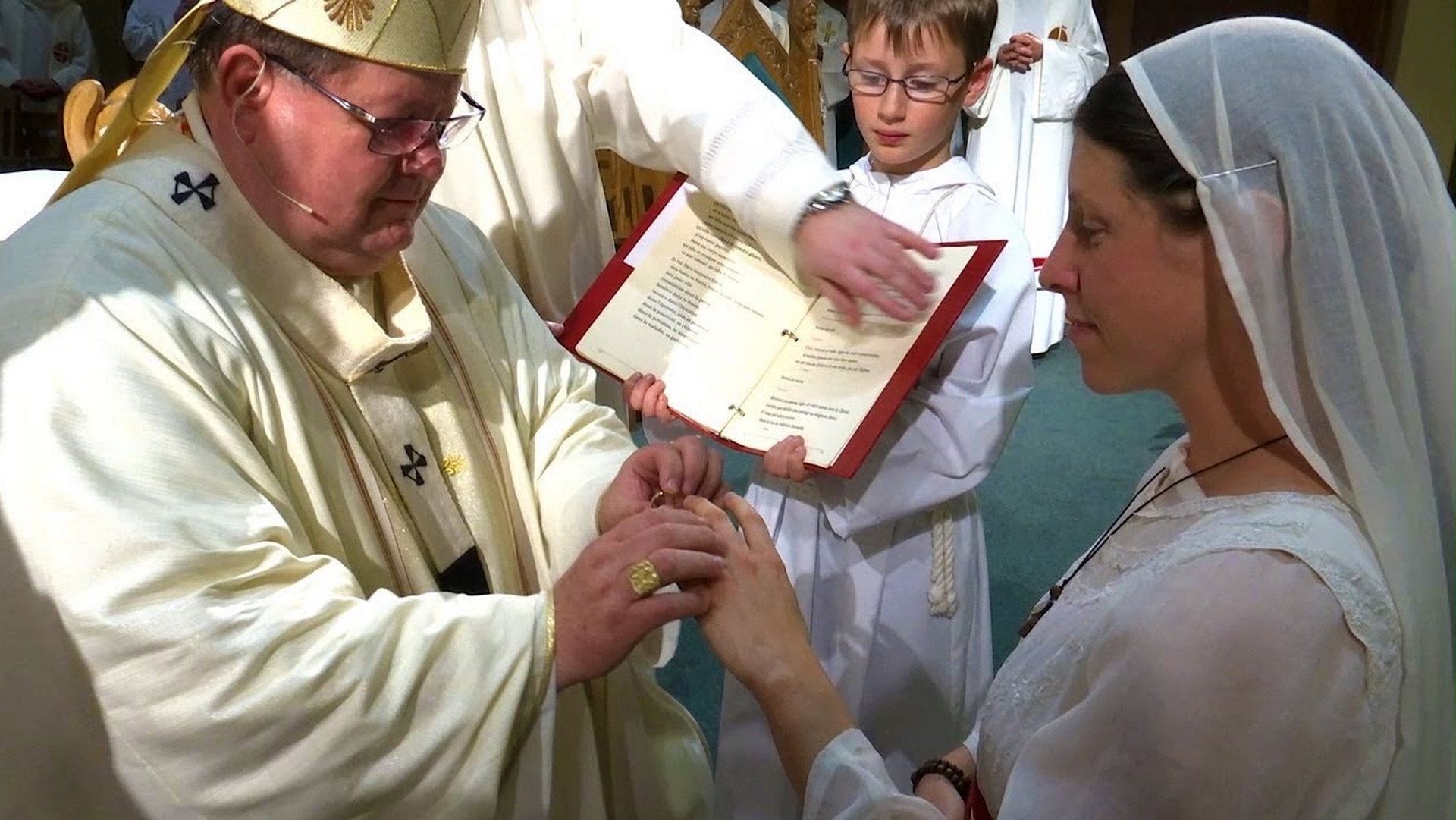 Une vierge consacrée remet sa consécration à l'évêque | capture d'écran Youtube 