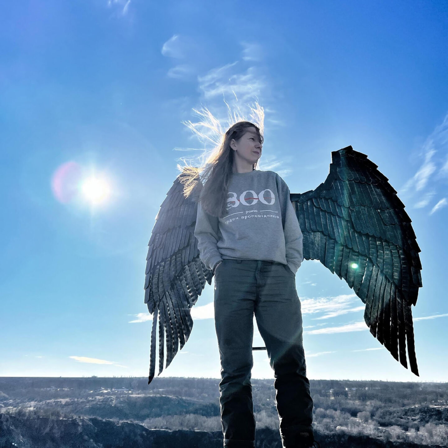 Katya, une humanitaire de la Maison de Saint-Martin de Porres, devient un ange le temps de poser devant ces ailes située au bord de la falaise surplombant le village de Myhija | © Jaroslaw Kraviec 