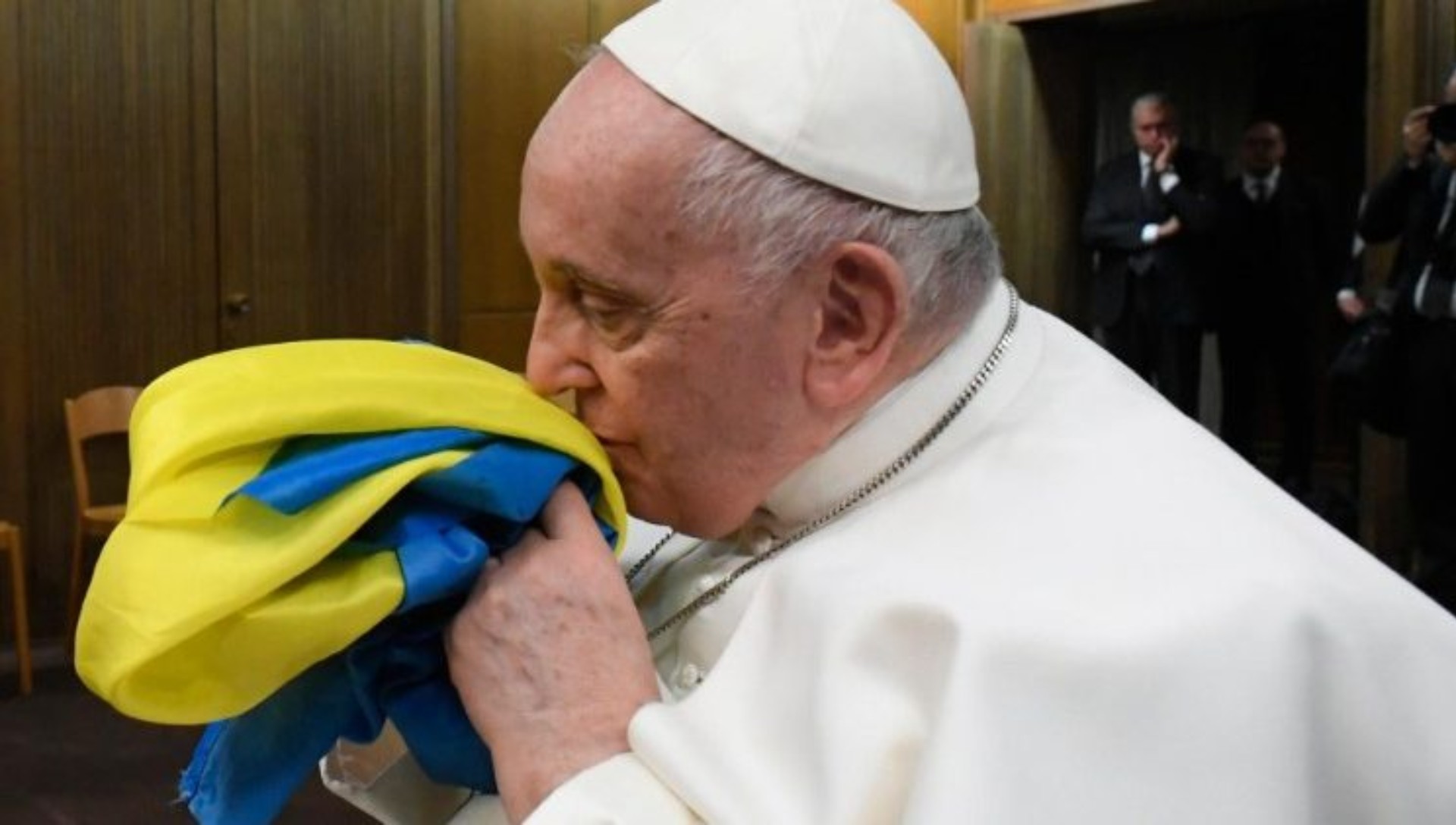 Le pape François embrasse le drapeau ukrainien lors de la projection d'un documentaire sur la guerre | © Vatican Media