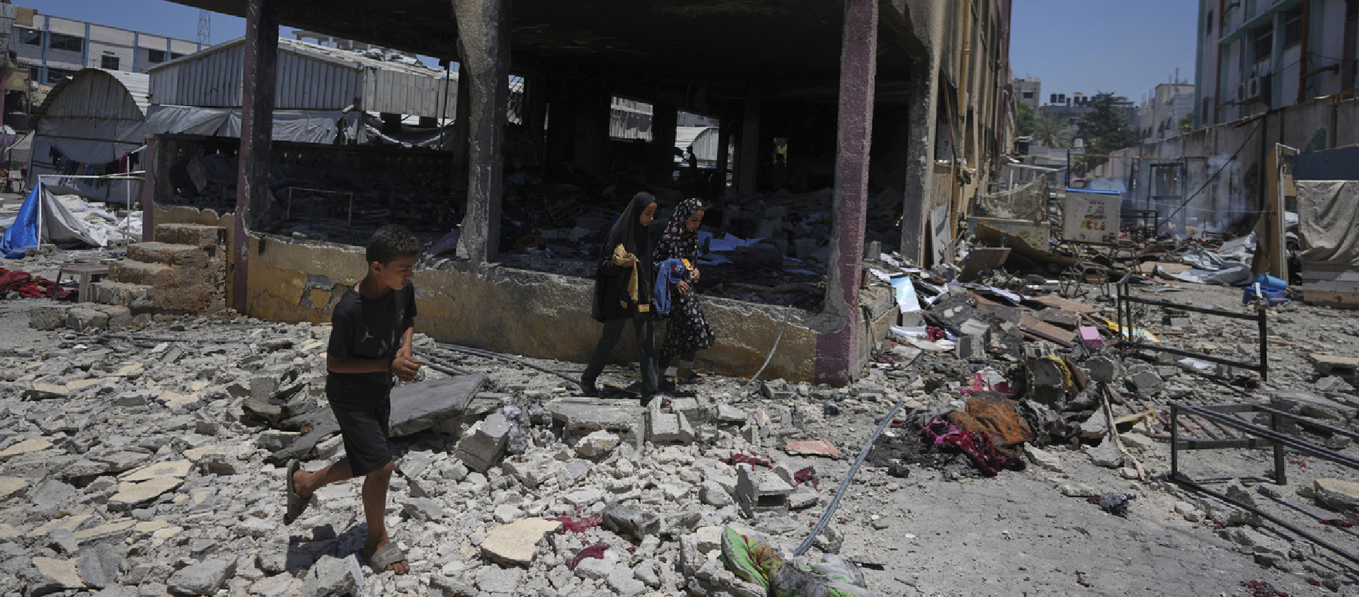 Des Palestiniens constatent la destruction d'une école utilisée comme abri après qu'elle ait été bombardée par l'armée israélienne à Gaza, le 3 juillet 2025 | © AP Photo/J. Alshrafi/Keystone