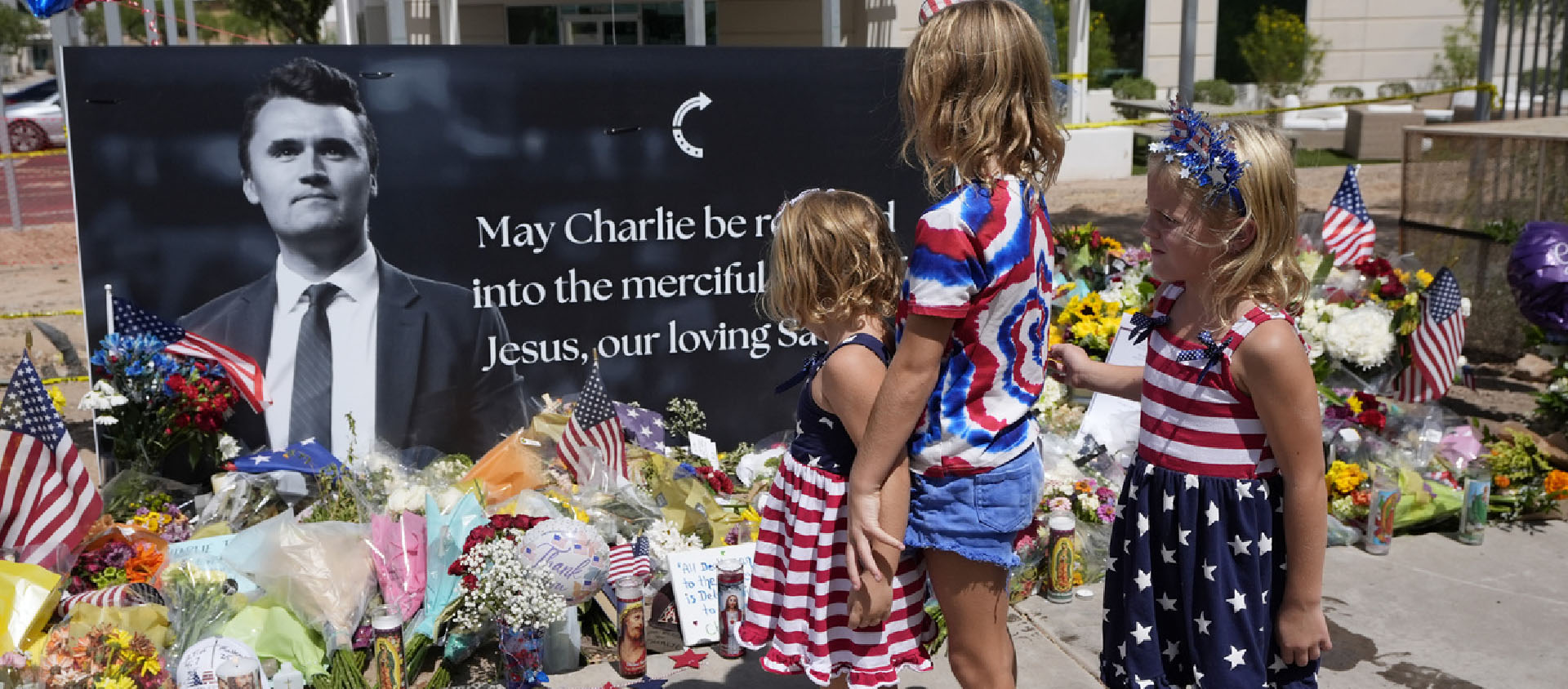 Des enfants passent du temps devant un mémorial improvisé installé au siège de Turning Point USA après la mort par balle de Charlie Kirk le 10 septembre 2025 | © Keystone/AP Photo/Ross D. Franklin