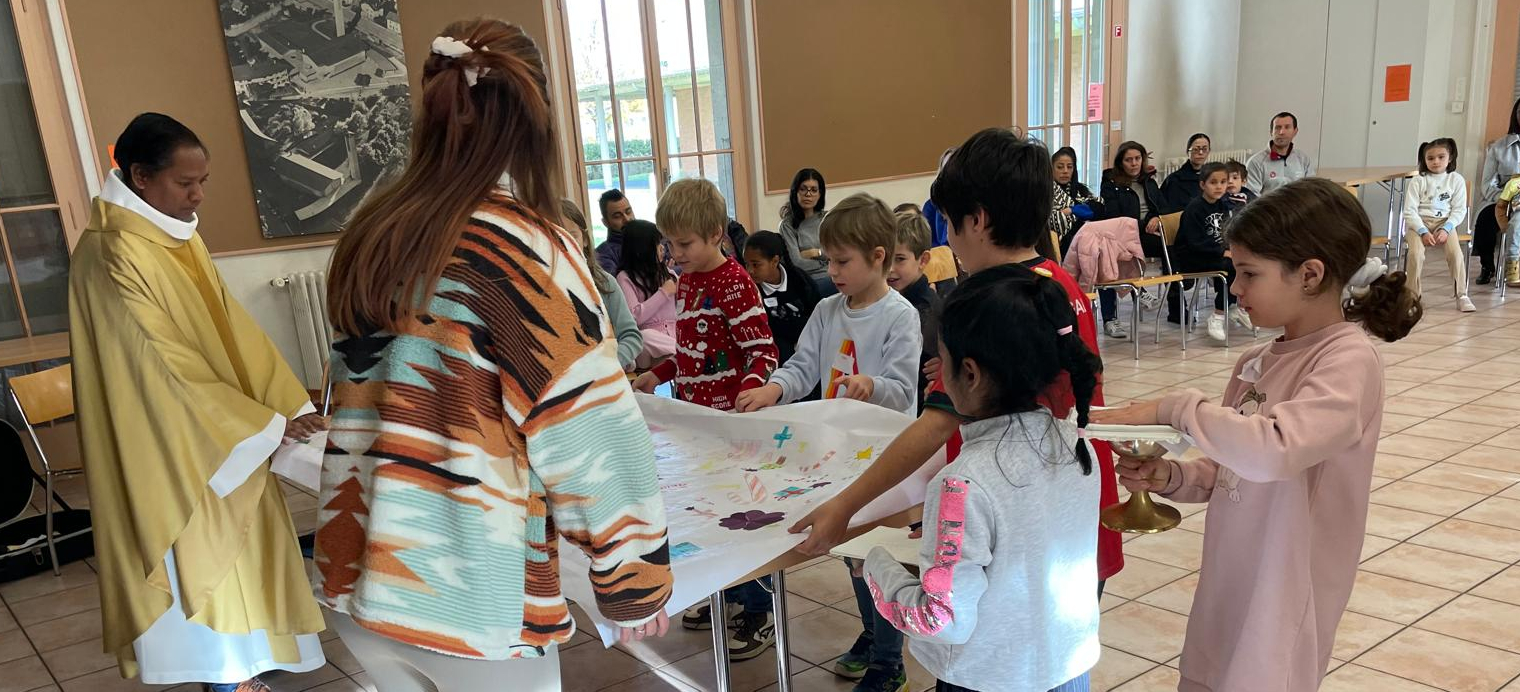 L'abbé Thadeus Lakra avec des enfants de l'UP du Plateau (GE), lors d'une "messe explicative" | © UP du Plateau