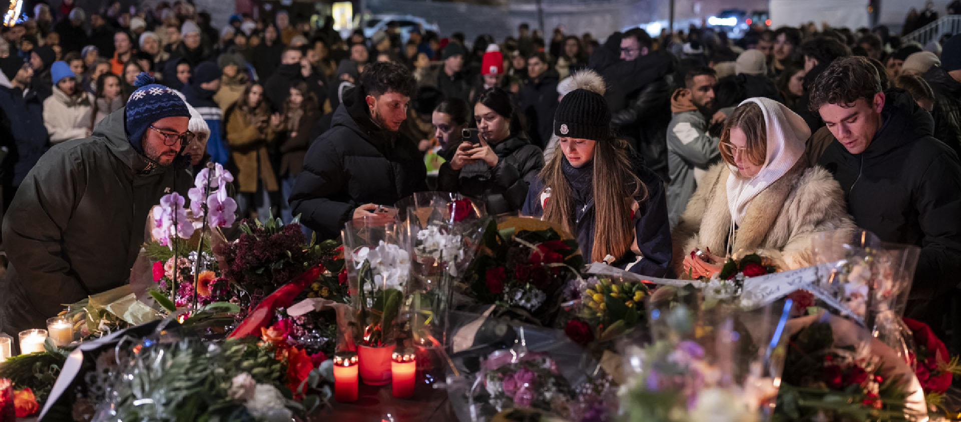 Vers 20h, le 1er janvier, plusieurs centaines de personnes se sont rassemblées pour déposer des fleurs et allumer des bougies en mémoire des victimes de l'incendie qui a ravagé le bar «Le Constellation» | © Keystone/A. Della Valle
