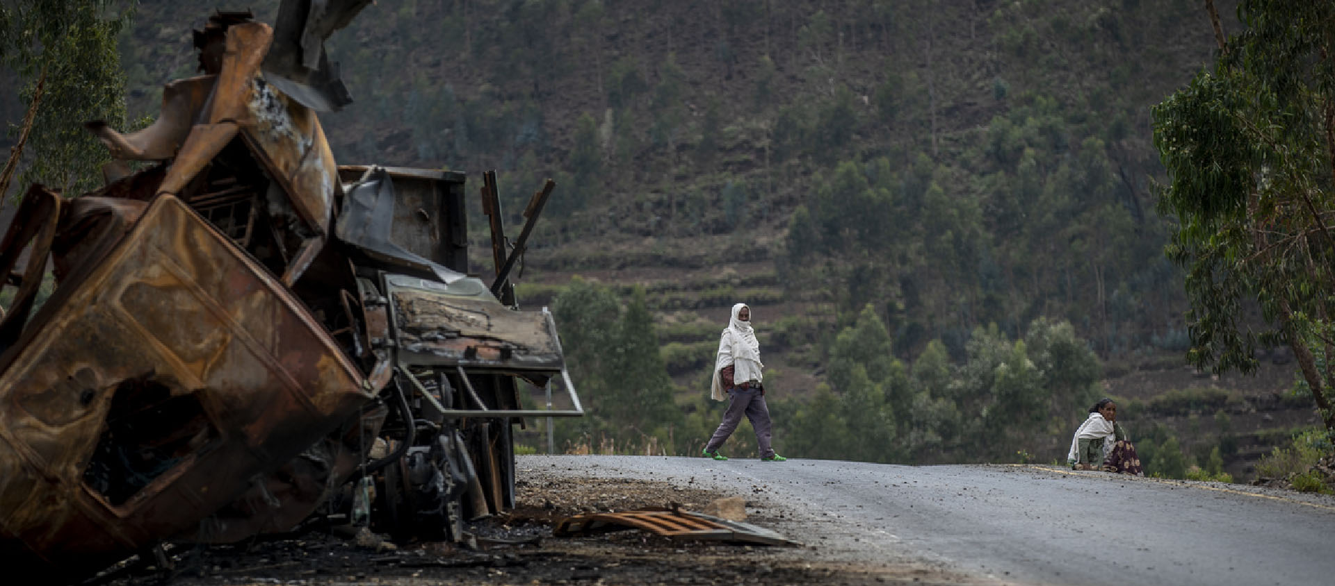 Un homme passe près d'un camion détruit sur une route menant à la ville d'Abi Adi, dans la région du Tigré, au nord de l'Éthiopie, le 11 mai 2021 | © Keystone