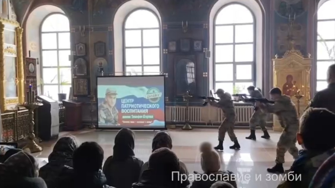 De jeunes para-militaires simulent un assaut à l'arme automatique contre la Vierge et les saints | capture d'écran 